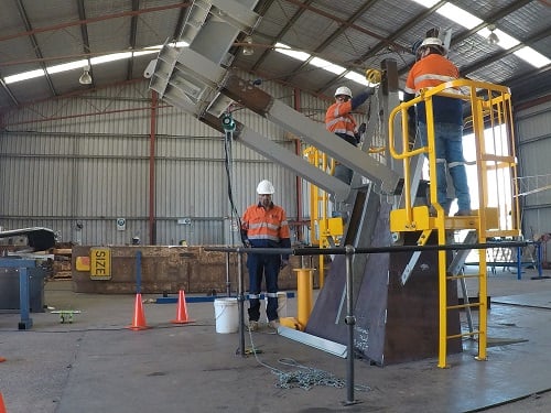Workers trialling the scale model of the shiploader top structure at a safe height in the Geraldton workshop