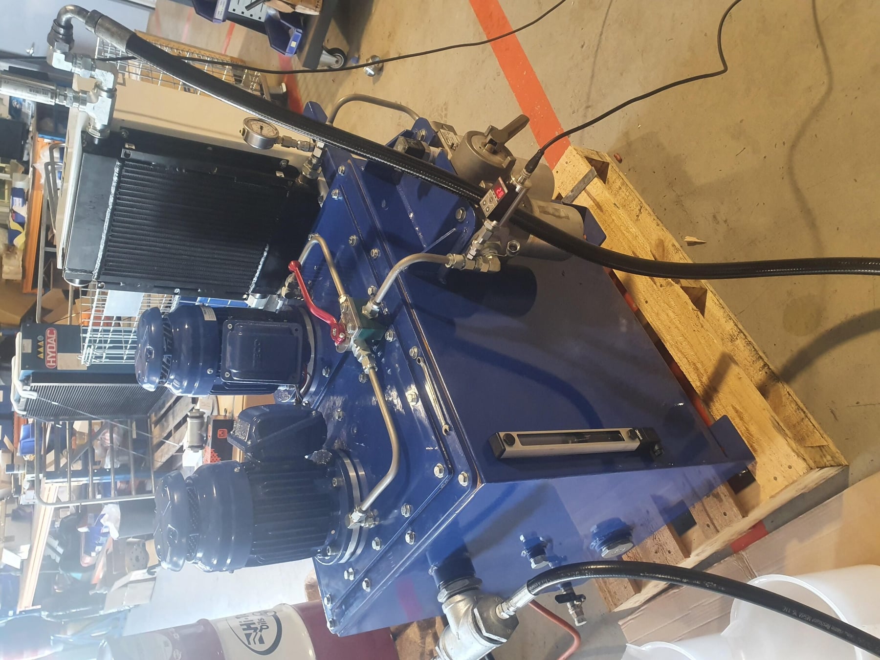 Hydraulic power unit with twin motors, cooler and level gauge on a pallet in the workshop