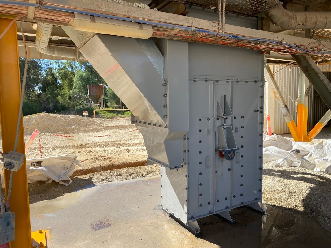 Fabricated transfer chute installed under a conveyor on a processing plant